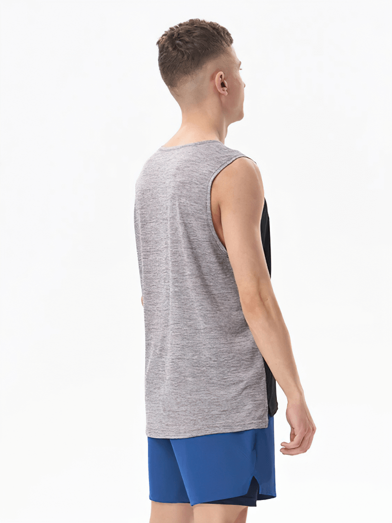 Man wearing a gray and black breathable gym tank top with blue shorts, showcasing lightweight broadcloth fabric for workouts.